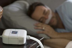 Man sleeping while using a CPAP sleep apnea device