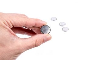 person holding a button-battery 