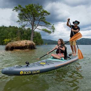man and woman paddle boarding on a gray Body Glove tandem paddleboard